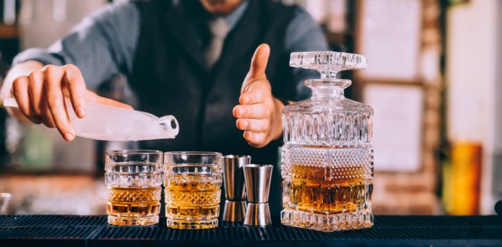 stock-photo-close-up-of-barman-hands-adding-ice-and-whiskey-to-modern-urban-cocktails-sky-bar-serving-elegant-764280106