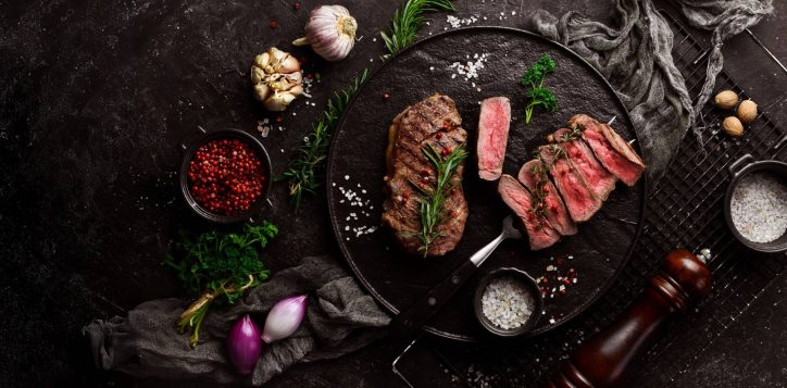 photo-grilled-ribeye-beef-steak-steak-fork-black-plate-top-view-black-stone-background-wide-2