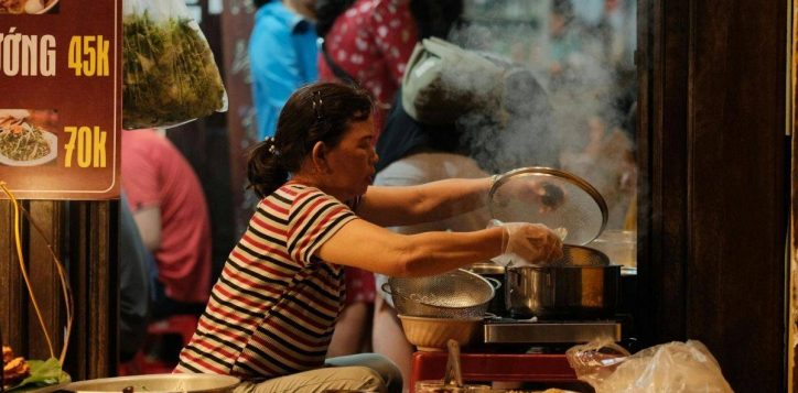 busy-food-stall-at-son-tra-night-market-with-a-cook-preparing-hot-dishes