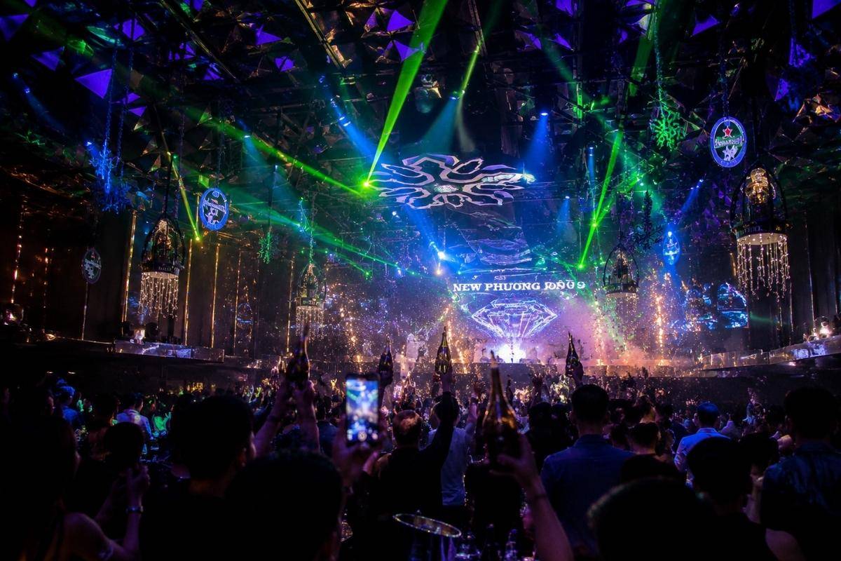Vibrant blue laser stage with an energetic crowd at New Phuong Dong Club Da Nang