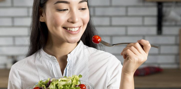 close-up-happy-asian-woman-eating-healthy-salad-1