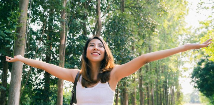 happy-young-asian-woman-traveler-with-backpack-walking-forest-1