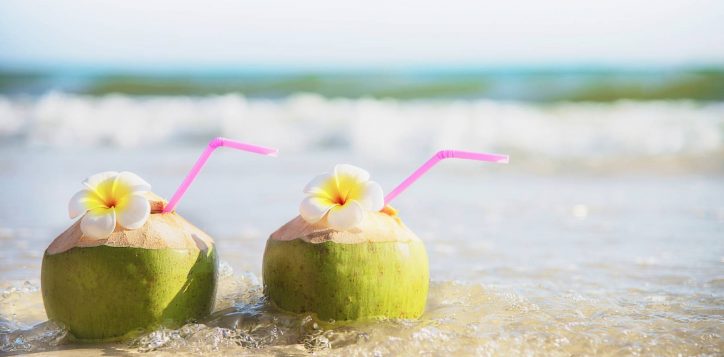 fresh-coconut-with-plumeria-flower-decorated-clean-sand-beach-with-sea-wave-fresh-fruit-with-sea-sand-sun-vacation-concept-2