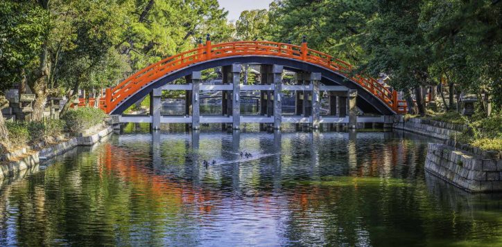 japan-traditional-wooden-arch-bridge-over-tranquil-river-panorama-osaka