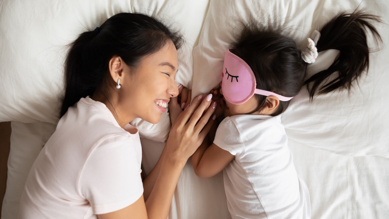 Smiling Mum watching little baby sleeping.