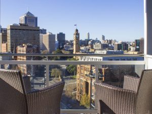 Two chairs on balcony with a view of Central Station clock tower and Sydney CBD