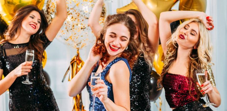 ladies-celebrating-their-college-graduation-home-girls-dancing-with-champagne-room-decorated-with-balloons