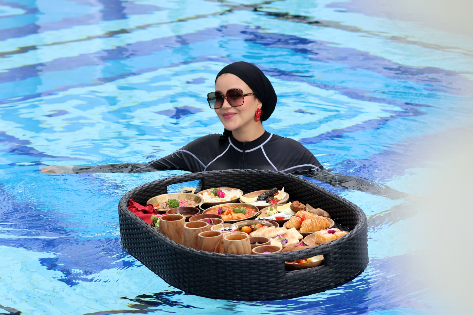 Muslim woman in swimwear enjoying a Middle East Floating Breakfast with Halal dishes in a private pool at Mövenpick Myth Hotel Patong Phuket