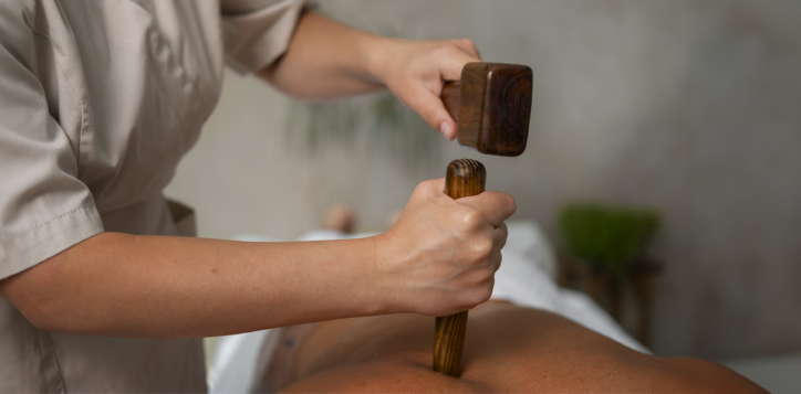 Therapist performing Tok Sen massage using traditional wooden tools at A VIDA Spa, Mövenpick Myth Hotel Patong Phuket