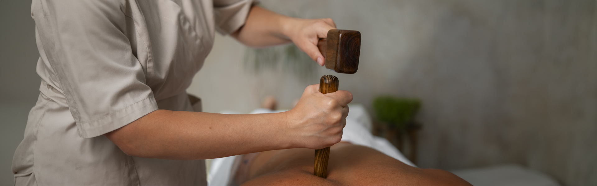 Therapist performing Tok Sen massage using traditional wooden tools at A VIDA Spa, Mövenpick Myth Hotel Patong Phuket