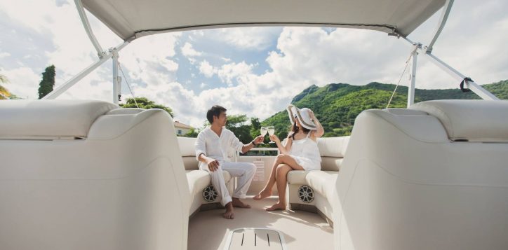 smiling-young-couple-holding-glasses-with-champagne-looking-each-other-while-sitting-board-yacht-2