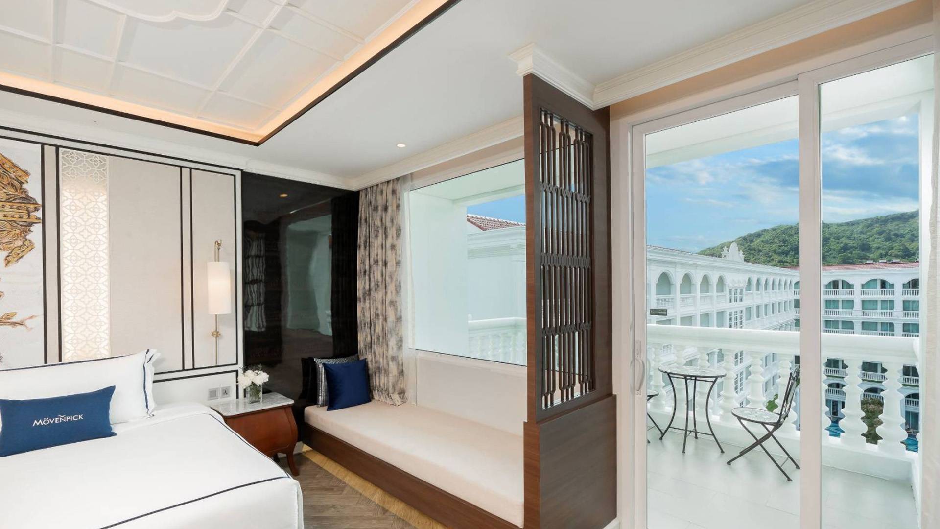 Modern hotel room at Mövenpick with balcony, mountain view, and outdoor seating