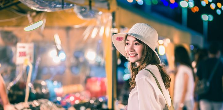 happy-traveler-asian-woman-with-backpack-travel-in-shopping-street-night-market-with-light-bulb-bokeh-at-bangkok-city-thailand-lifestyle-holiday-vacation-concept