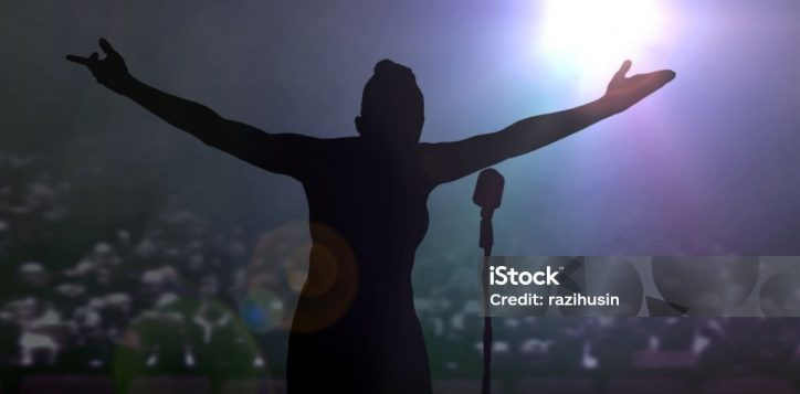 women-bowing-on-stage-after-a-concert-under-bright-spotlights