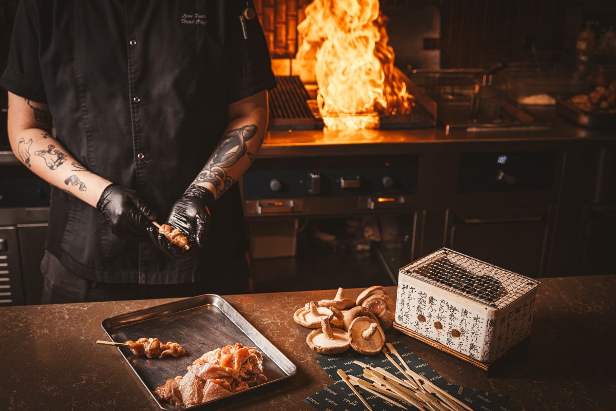 MOGA Sizzle Saturdays skewers preparation by chef with raw meat and mushrooms, fire in background