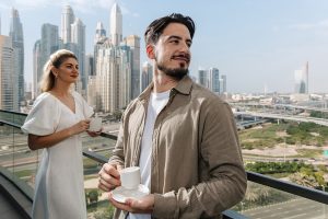 Couple enjoying the balcony view at Pullman JLT, luxury hotel near Dubai Marina with city and marina views.