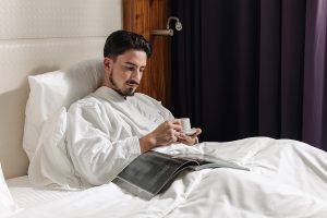 Guest relaxing on the bed at Pullman JLT, luxury hotel near Dubai Marina with modern rooms and comfortable interiors.