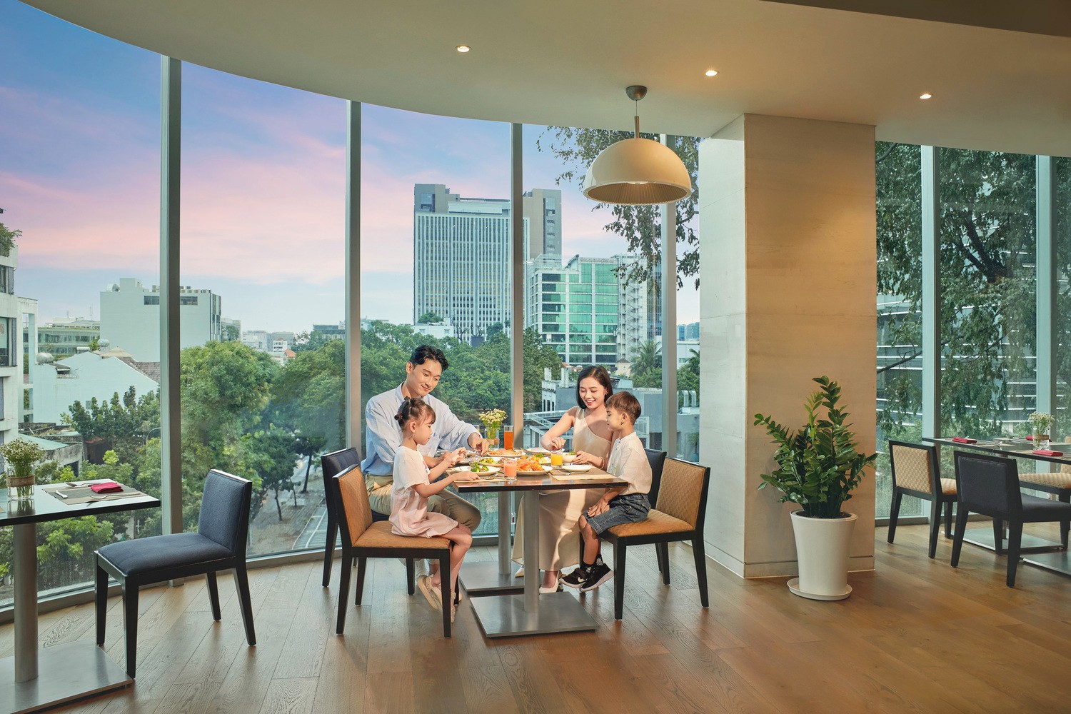 Guests enjoying breakfast at Novotel Saigon Centre restaurant with panoramic Ho Chi Minh City views.