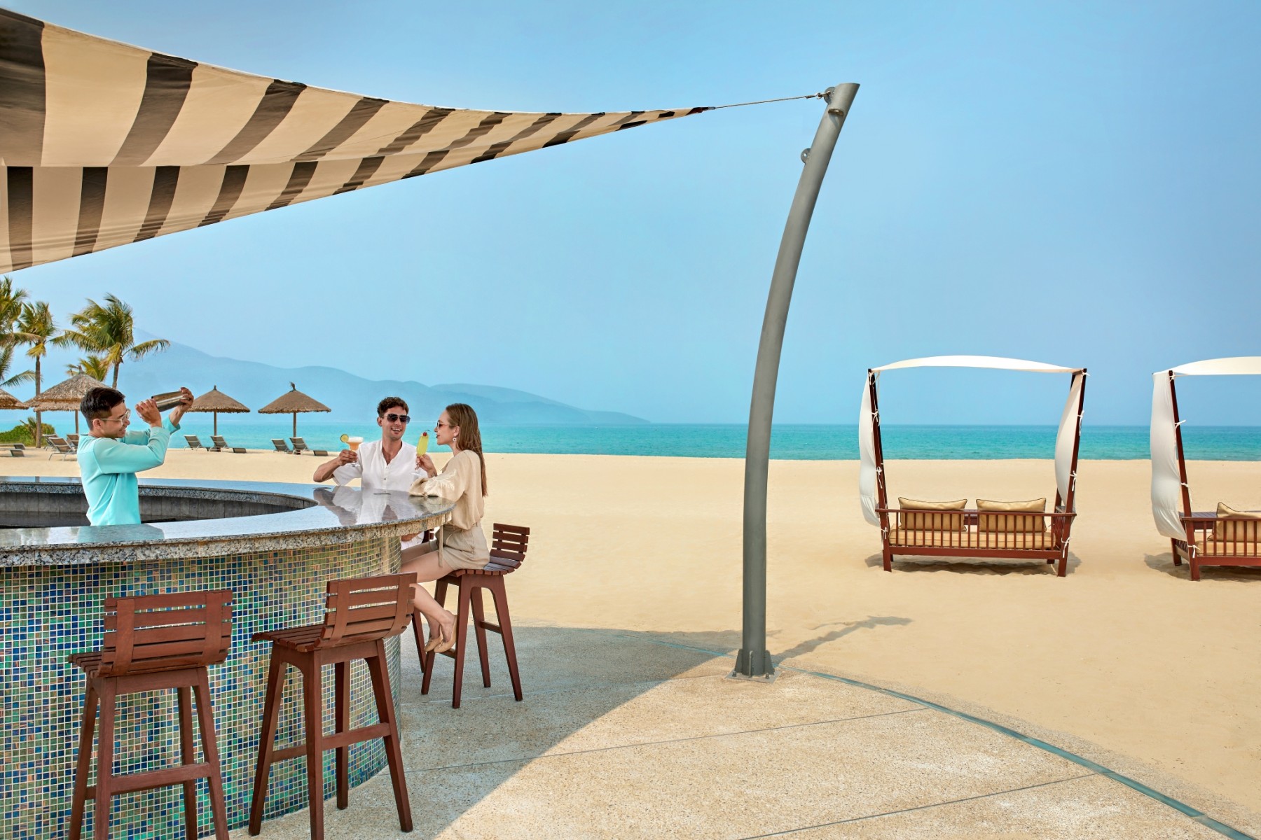Pullman Danang Beach ResortのAzure Beach Barでドリンクを楽しむカップル