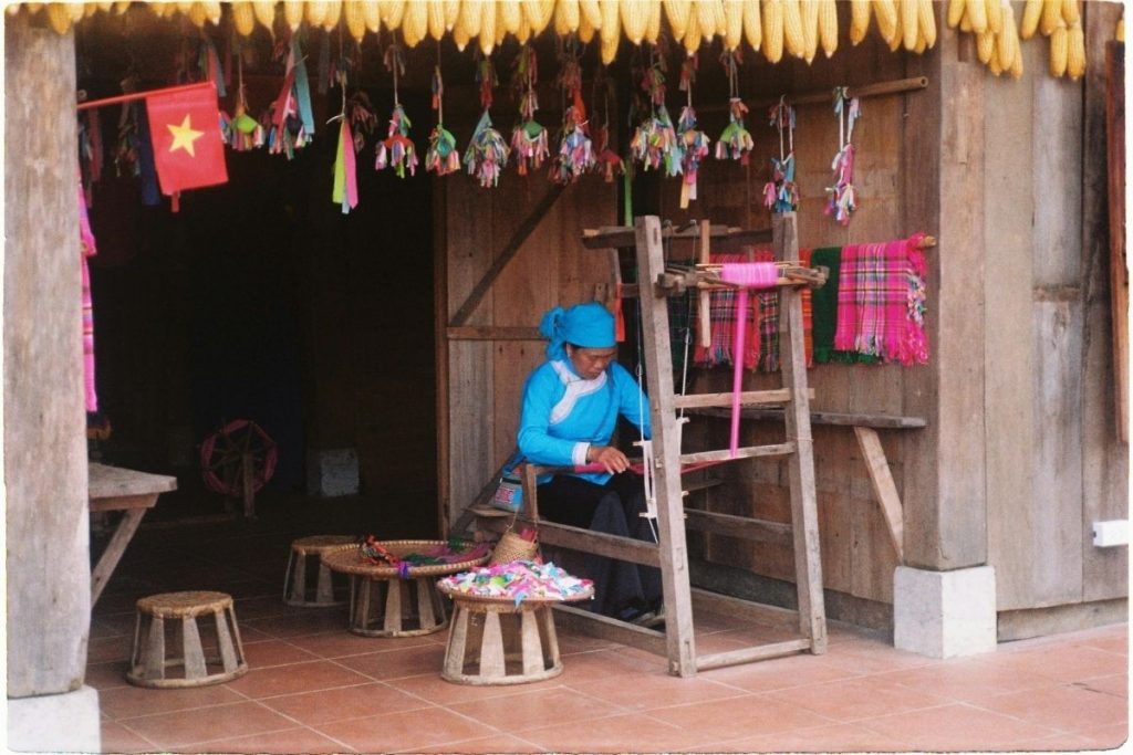 A person weaving on a wooden loom at the 4th hoi an traditional craft festival