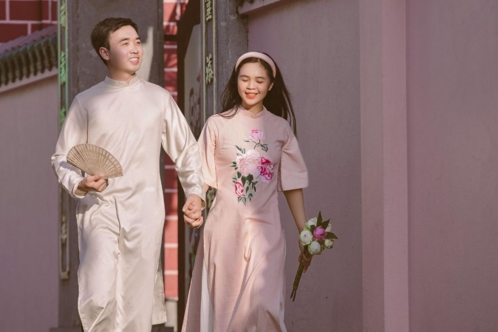 A couple in traditional clothing walking together and smiling
