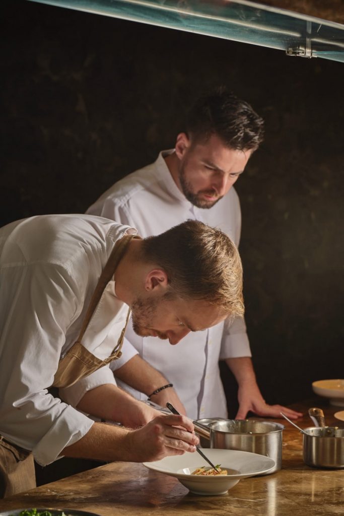 Chef Christopher Clarke in the kitchen with Chef Kirk Westaway, collaborating to bring modern British cuisine to life at The Albion in Saigon.