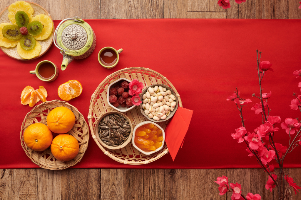 Decorative Tet display featuring red envelopes (lì xì), peach blossoms, and Tet treats.