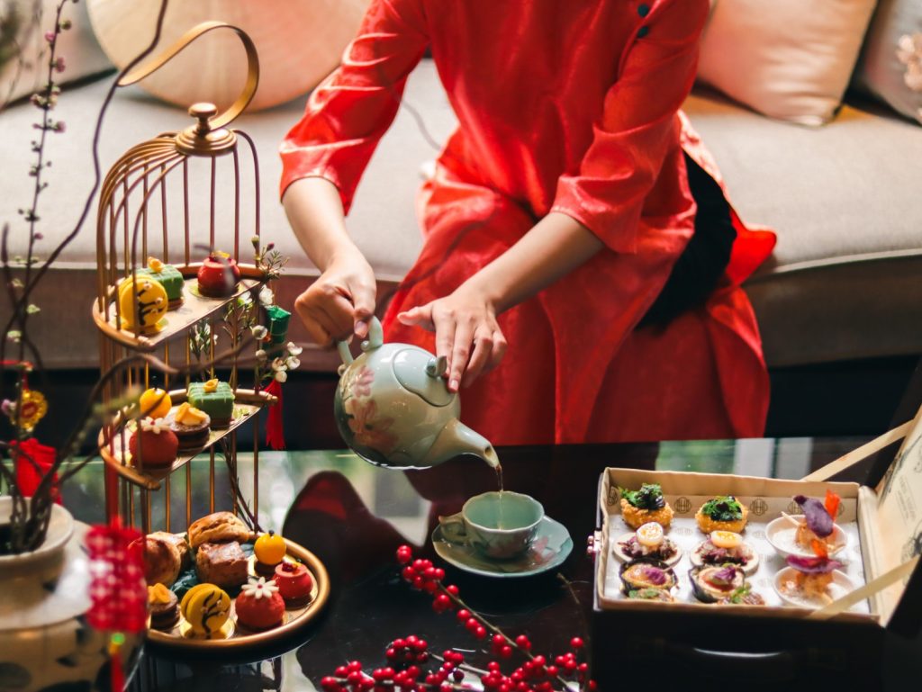 Guests enjoying a Tet-inspired afternoon tea at Hôtel des Arts Saigon in a festive, elegant setting