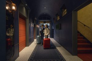 female and male with luggages at the hotel entrance